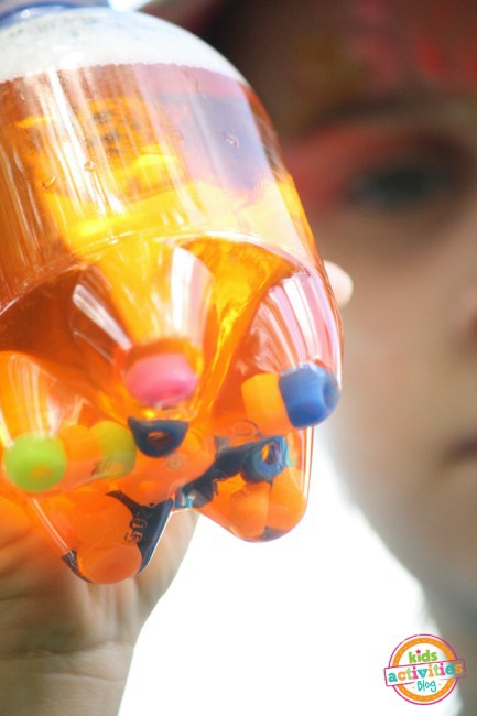 bottle filled with orange water and beads