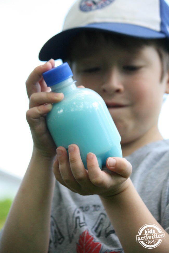 shaking a bottle of blue water and soap