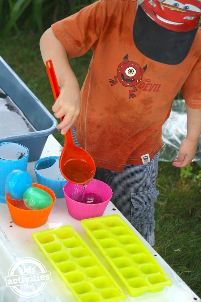 scooping and pouring from coloured ice activity bin
