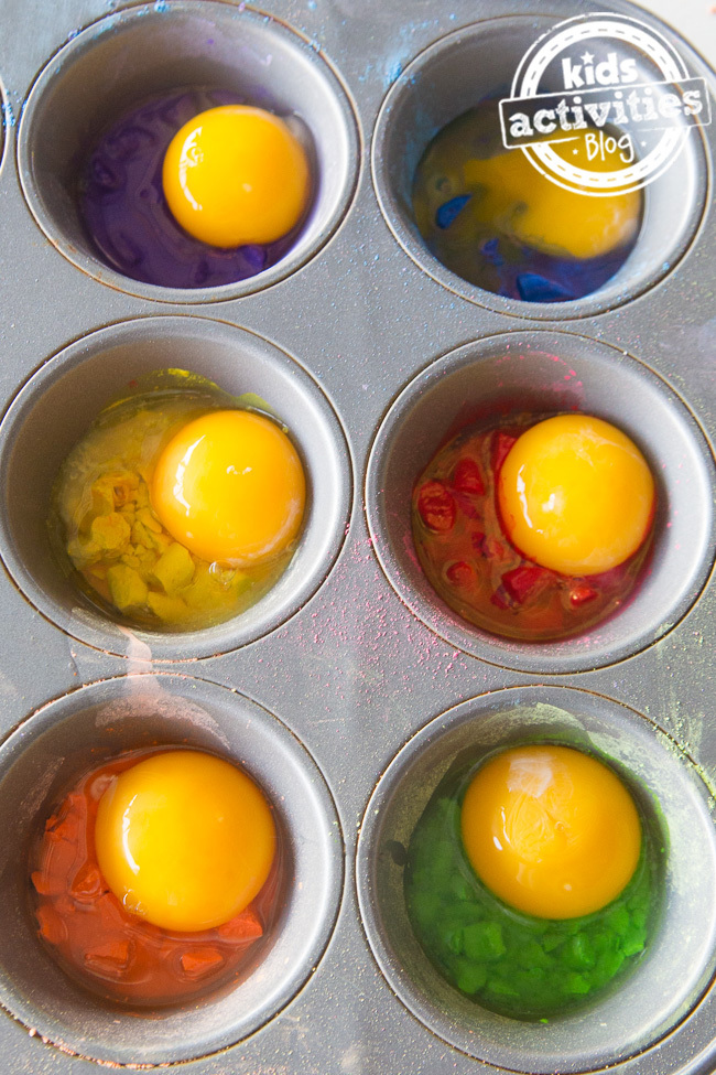 Egg yolk and chalk homemade paint recipe shown in progress of being made with egg yolks on top of brightly colored chalk in a muffin tin