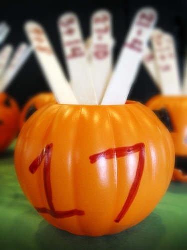 Halloween math - pumpkin with number on side shown with popsicle sticks inside that have math problems on them
