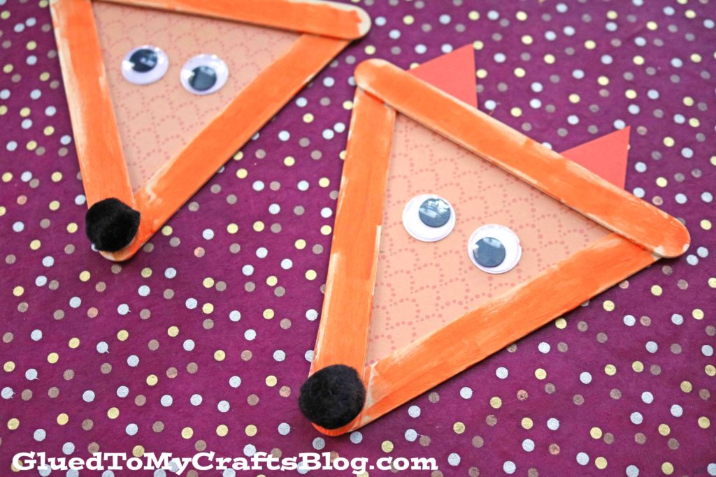 popsicle stick fox craft for kids from Glued to My Crafts Blog - two finished popsicle stick foxes shown with googly eyes