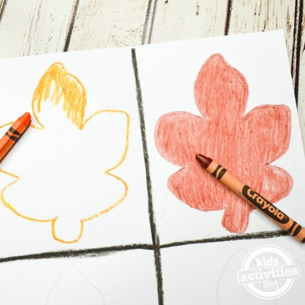 Outline the leaf cookie cutter in this fall art with crayons that are fall colors like orange, red, yellow, brown, gold, and color them in.