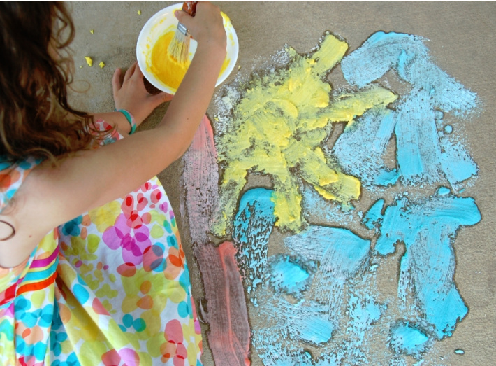 homemade fizzy sidewalk paint recipe for kids from Kids Activities Blog - girl painting a picture with fizzy sidewalk paint