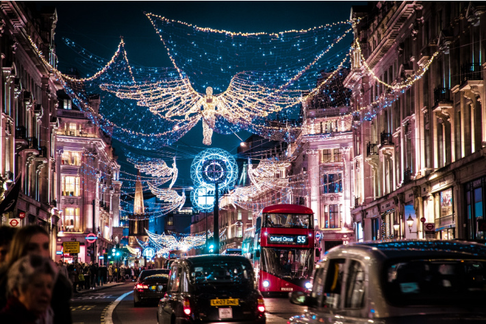 Christmas light town scene from London with holiday lights above street including an angel