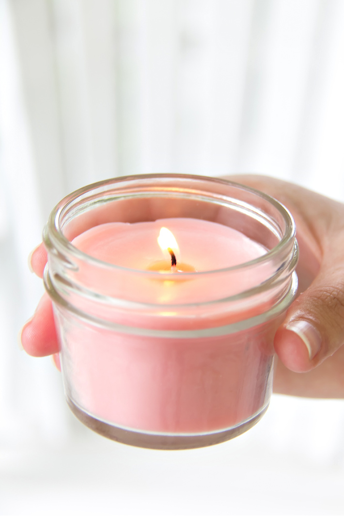A pink homemade candle made with melted crayons and soy wax. 