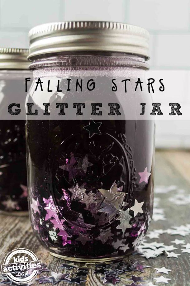 A mason jar filled with purple water, clear glue and silver confetti with a lid on top. There is a second identical jar in the background.