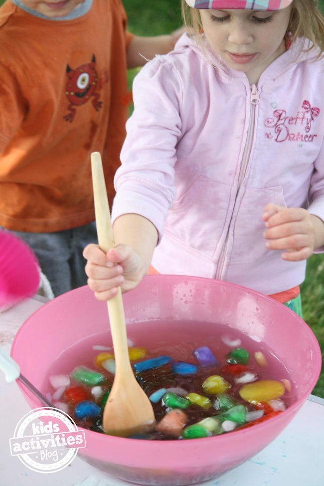 stirring coloured ice in a bowl of water