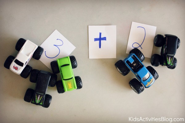 monster trucks math with numbers written on cards and plus sign.