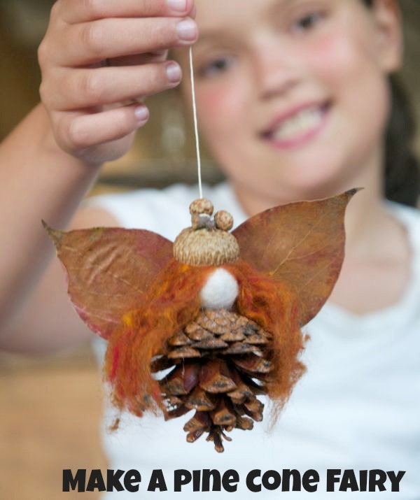 Make a leaf and pinecone fairy from The Magic Onions - finished fall craft shown with child holding leaf fairy hanging from string