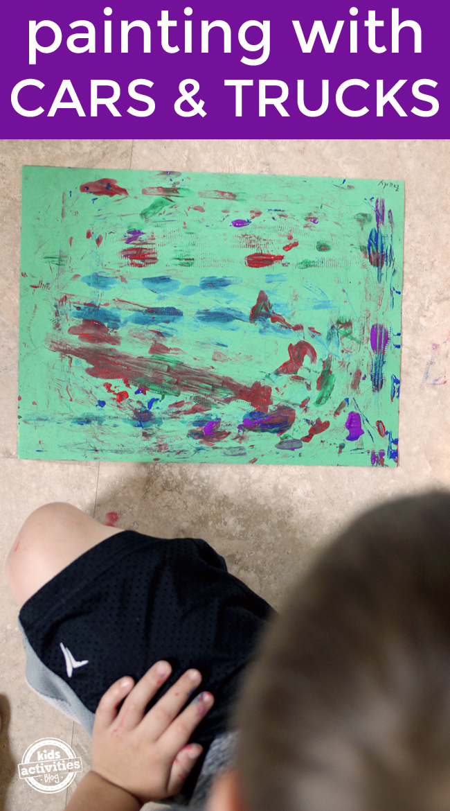 Painting with Monster Trucks preschool art activity for kids - finished art project shown with child