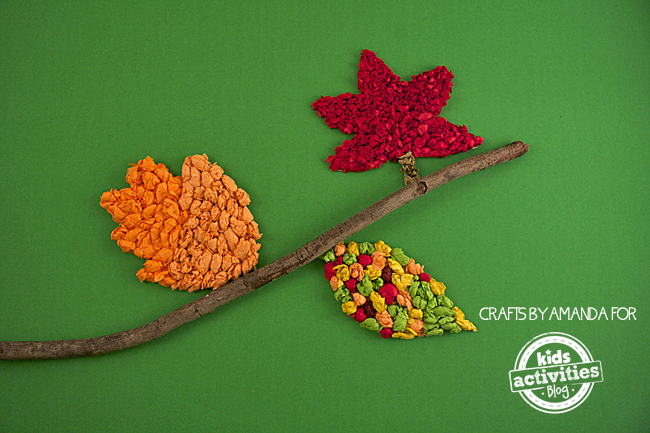 Fall Craft: Tissue Paper Leaves shown next to a stick as a tree limb with autumn colors like orange, red and colorful combination