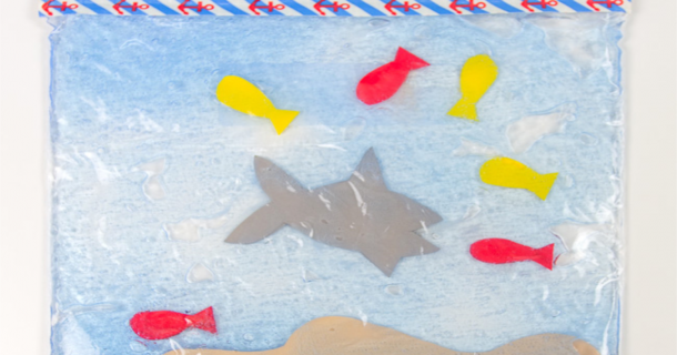 Feed the shark sensory activity - shark with fish all around in the portable sensory bin activity