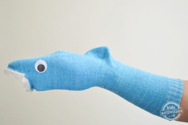 A man wearing Shark sock puppet is shown