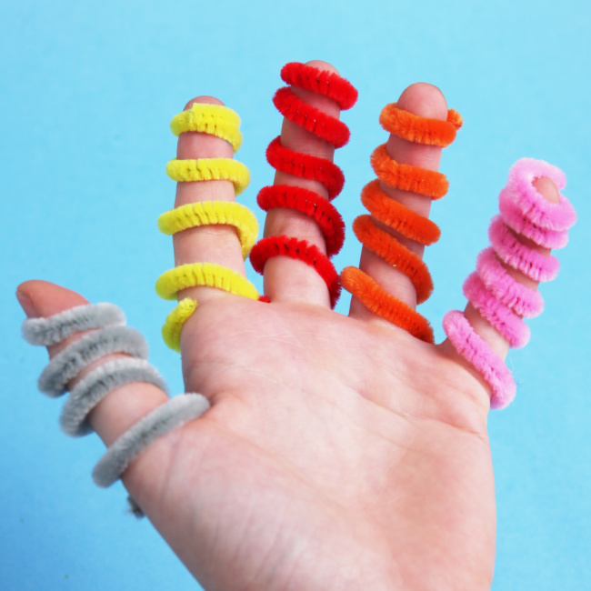 An assortment of pipe cleaners shown on the fingers of a child - Kids Activities Blog
