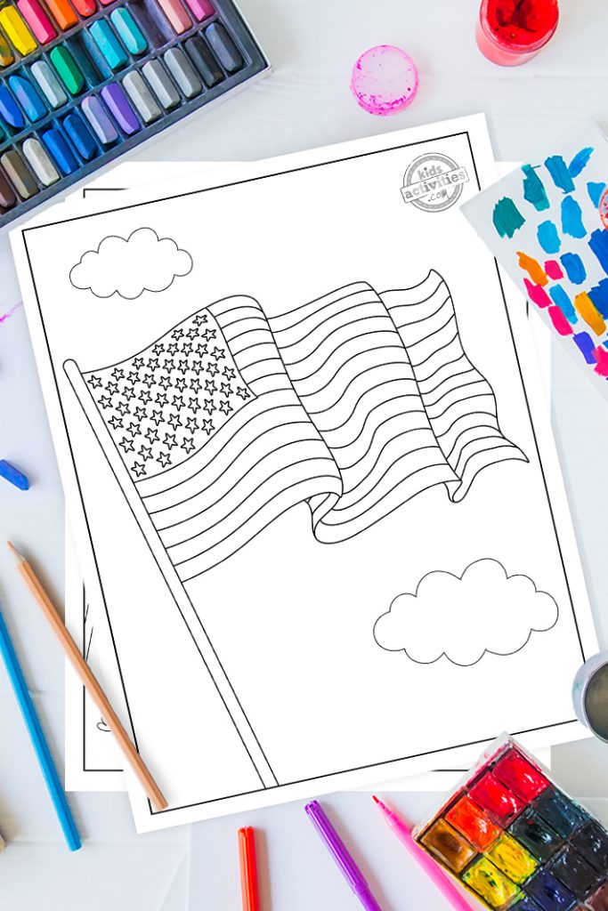 American flag coloring page on a desk with paint, pastels and art supplies