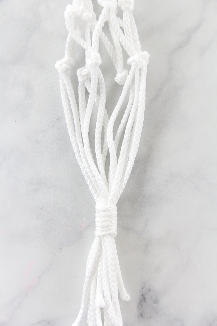 Instructions for securing a macrame plant hanger for a plant to sit inside.