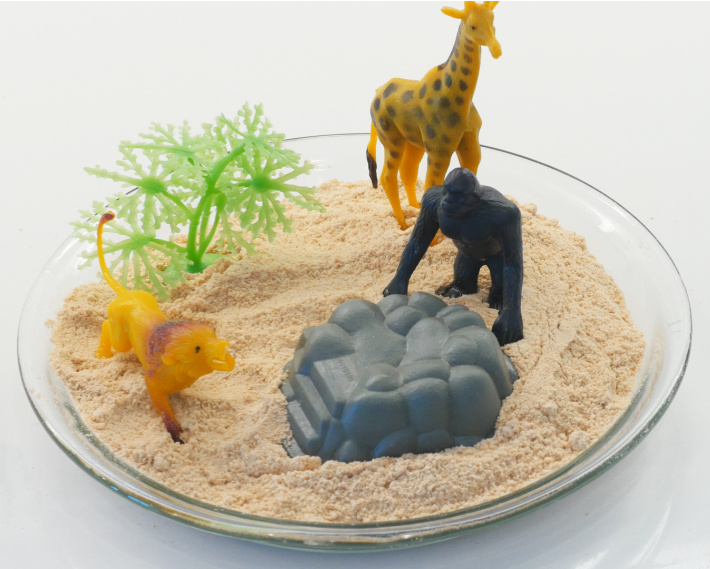 Finished edible sand with sand toys in deep baking dish ready for play