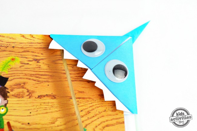 origami shark bookmark on book biting the corner of a page