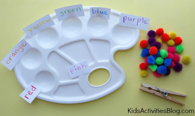 Fun color matching game that doubles as a fine motor skill game for preschoolers using paint palettes, pom poms of many colors, and a clothes pin.