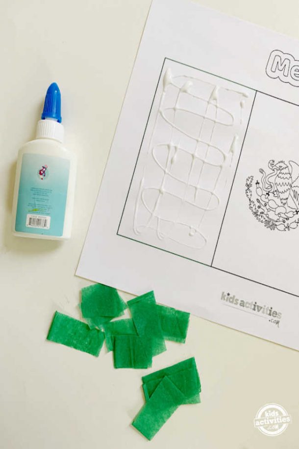 glue smeared to stick the tissue paper square on the free mexican flag printable to make mexican flag activities