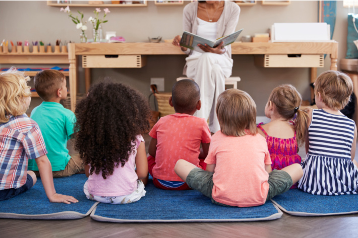 Kindergarten classroom with kids sitting for story time - Kids Activities Blog