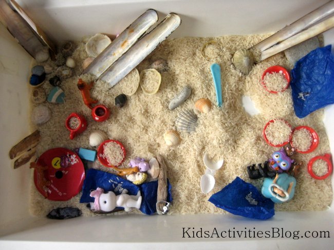 The seaside ocean sensory bin made at home with rice, toys, shells and more