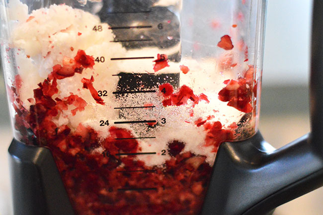 Adding sugar to the cranberry sugar scrub blended fruit,