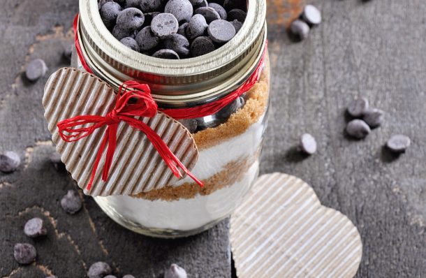 cookie ingredients layered in a mason jar with a twine tie and hearts