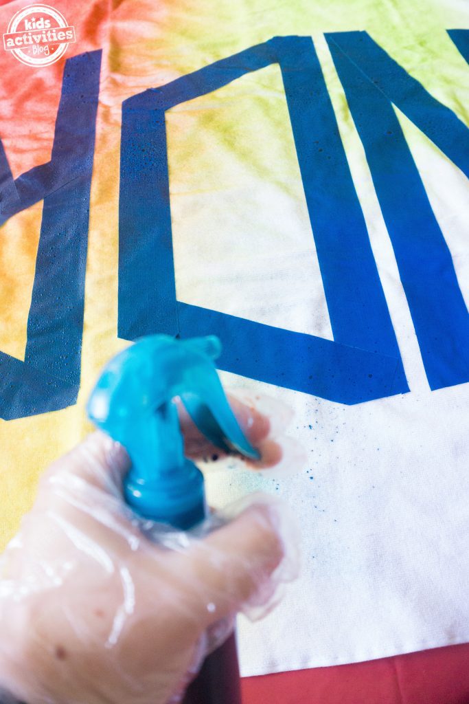 Personalized Tie Dye Beach Towel - step 3 with gloved hands start to spray on the tie dye