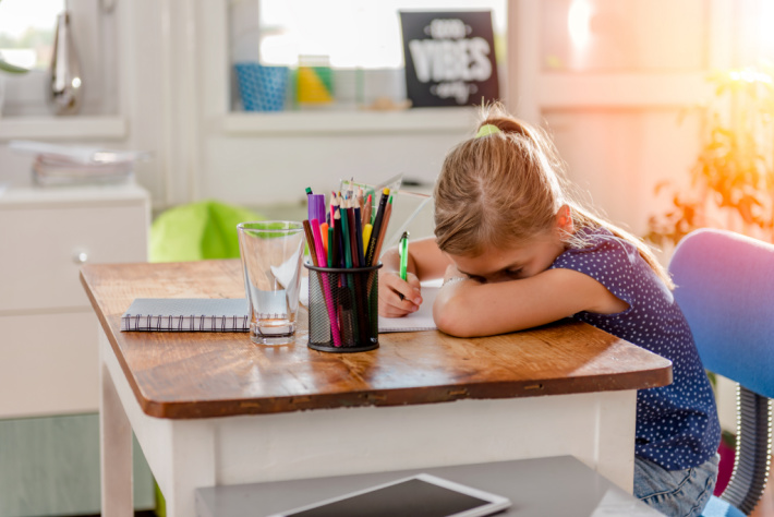 Girl tired writing at desk at home - Kids Activities Blog