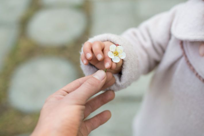 Fine motor control - child holding a flower in pincher grip - Kids Activities Blog
