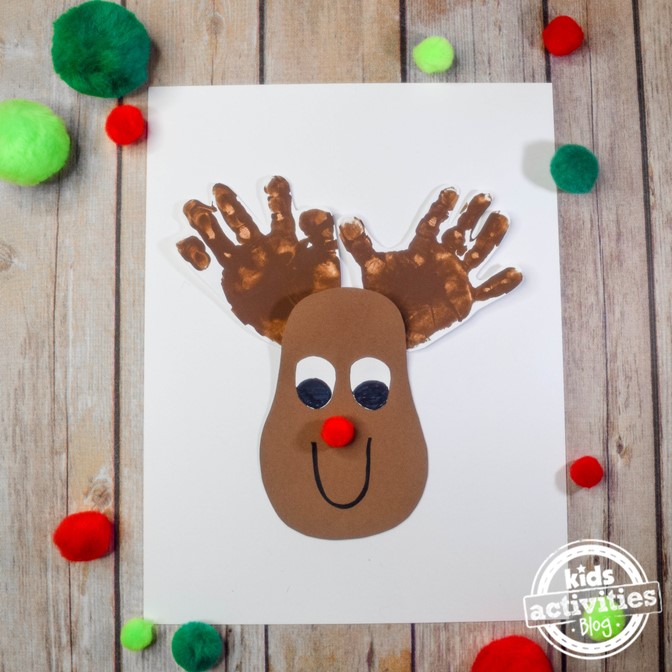 Rudolph the red nosed reindeer has handprint antlers and a pom pom nose