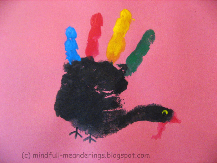 handprint turkey - black paint body with colorful feathers on pink background