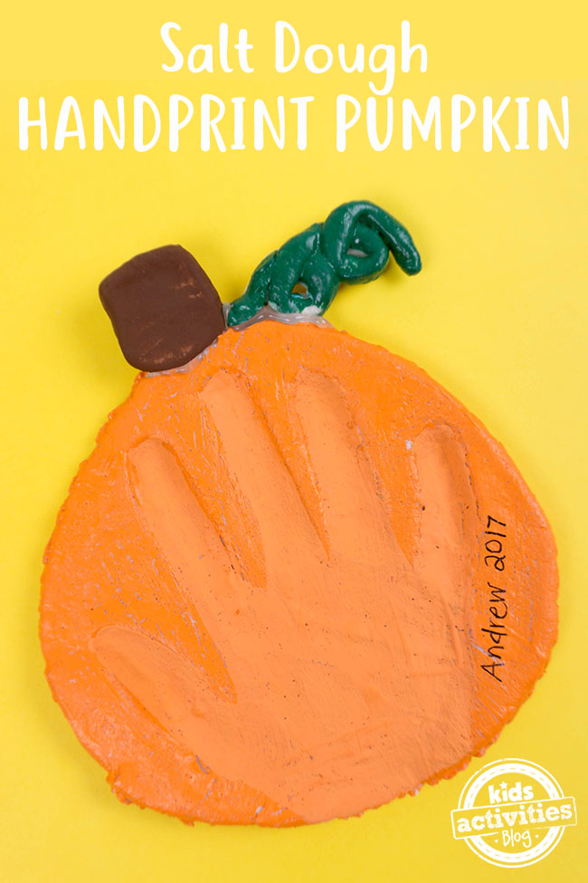 handprint in a salt dough pumpkin which is orange with a brown stem and green leaf