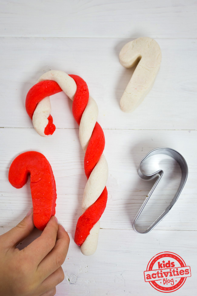This is one of our favorite candy cane activities for toddlers because they can twist the red dough and white dough to make candy canes or use a metal candy cane cookie cutters to cut out red candy canes or white candy canes.