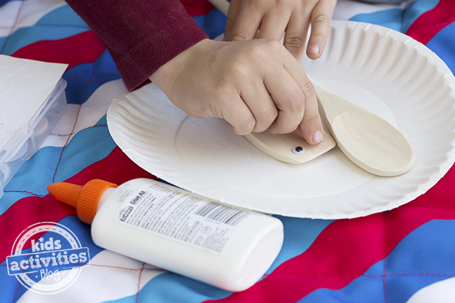 Use crafting glue to glue googly eyes onto the wooden spoons.