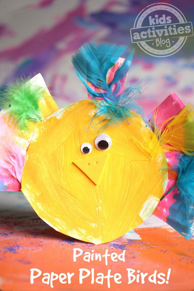 bird craft that is made from paper plate, feathers, googly eyes, and paint.