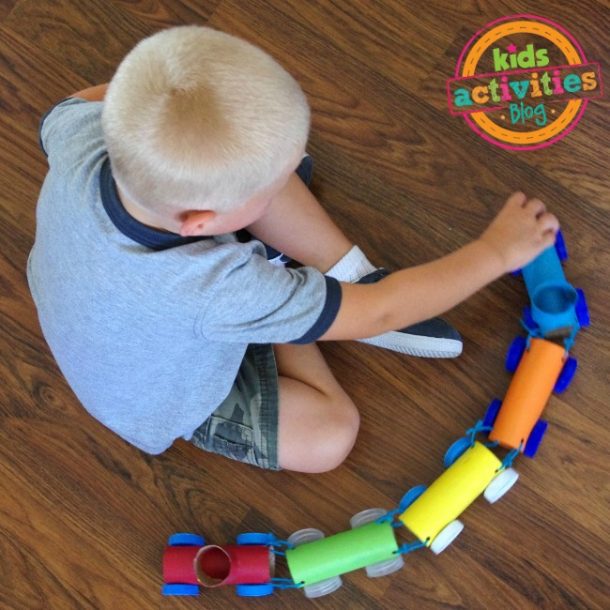Screen free activities like this toilet paper roll train this little boy is playing with!