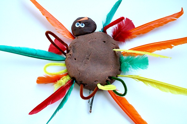 Playdough turkey with feathers and pipe cleaners